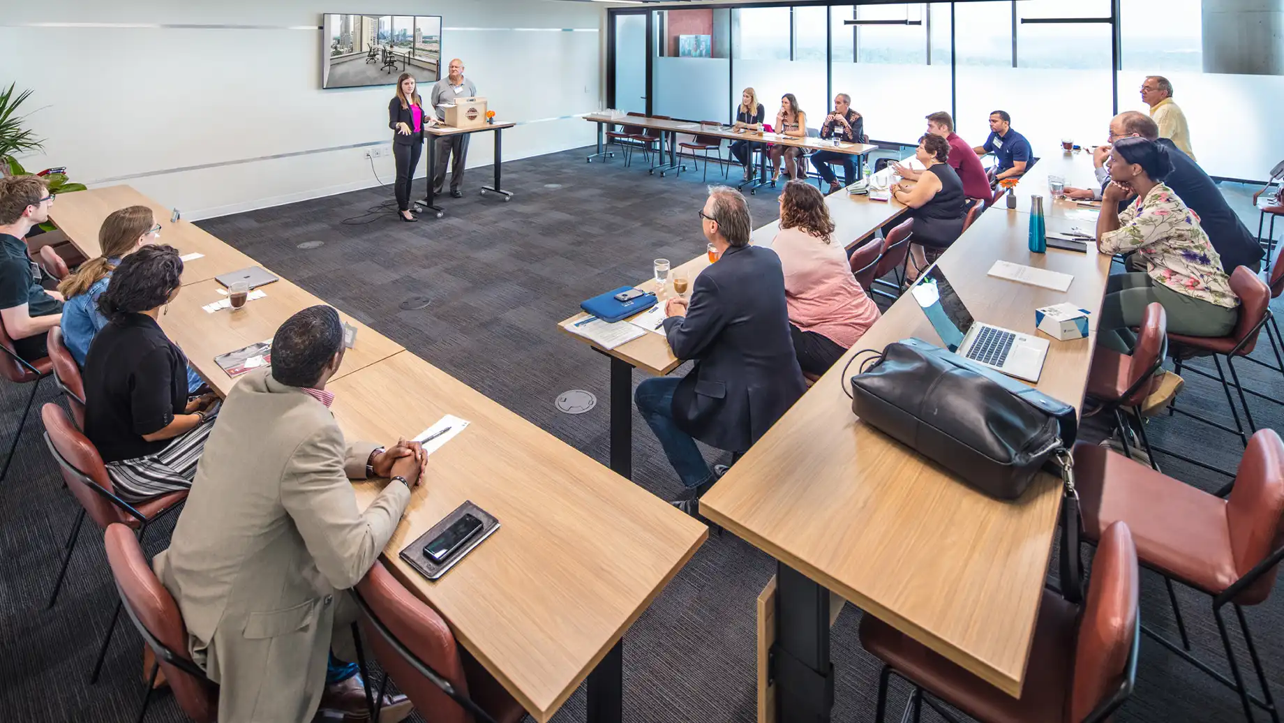 Presentation being given to a group of individuals in the Ideation Studio with hosts utilizing the built-in A/V system. Buckhead Atlanta Private Office & Coworking Space, Conference and meeting rooms.