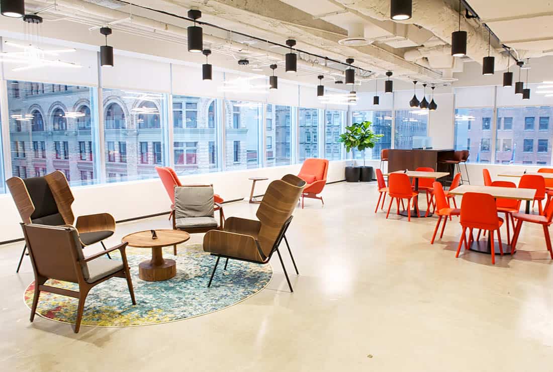 Coworking area with a bright view of the city through large windows.