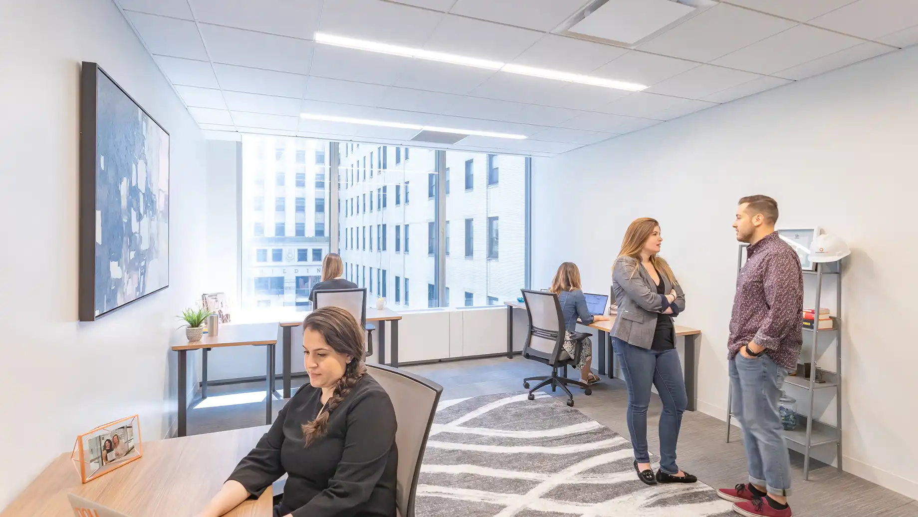 Woman working in a one person private office with a view of the city. Private Office & Coworking Space in Financial District NYC