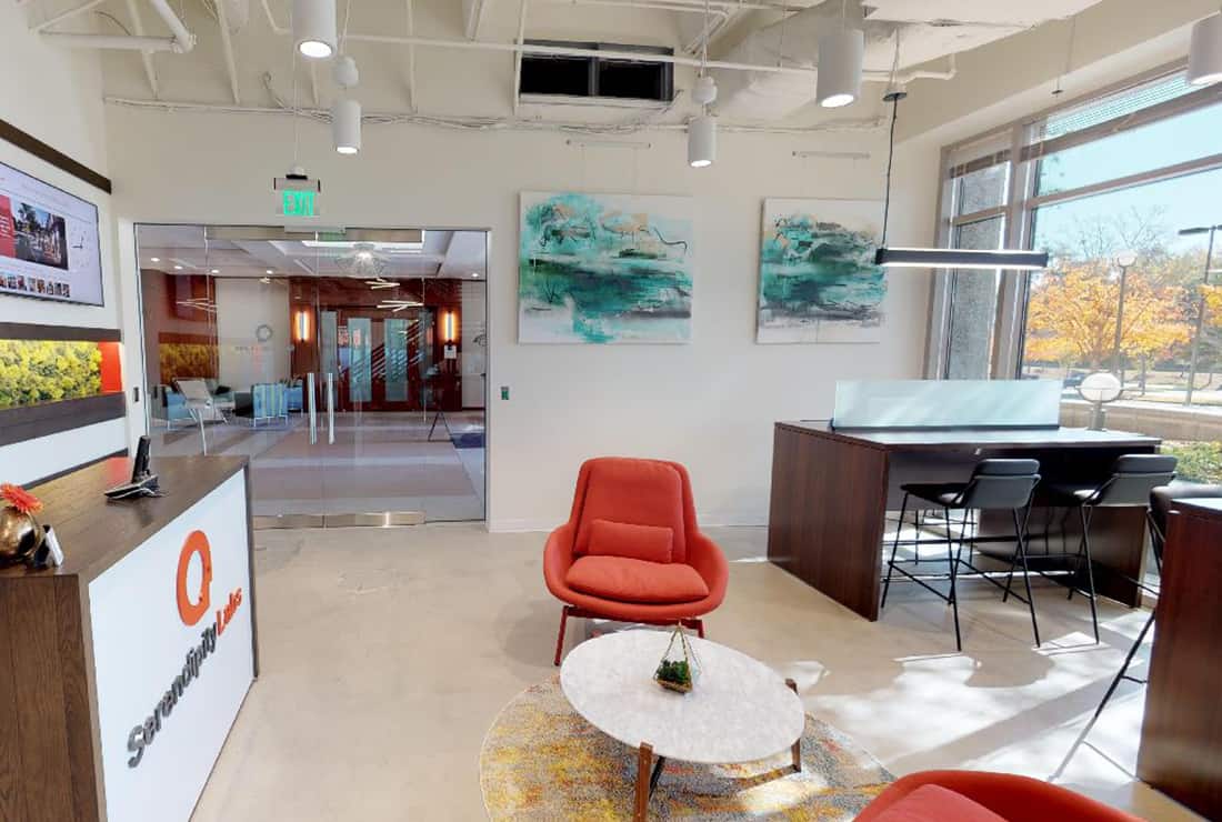 Main entrance with front desk, open Coworking, and views to outside.