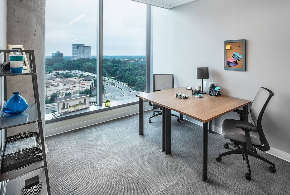 Private two person office with large window view of the city.