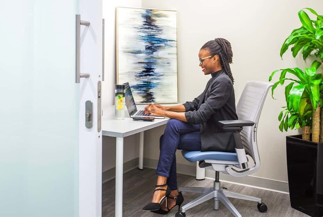 Woman working independently in a one person private office.