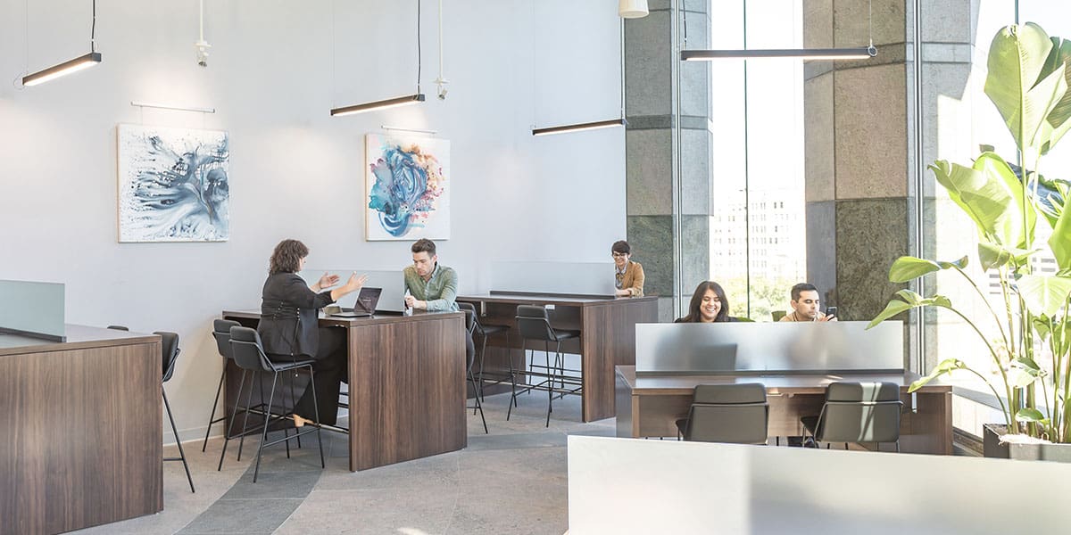 Men and women working independently at their Coworking desks.