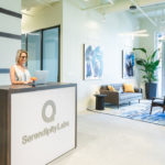 Experience Coordinator working at front desk next to private offices and Coworkingseating.