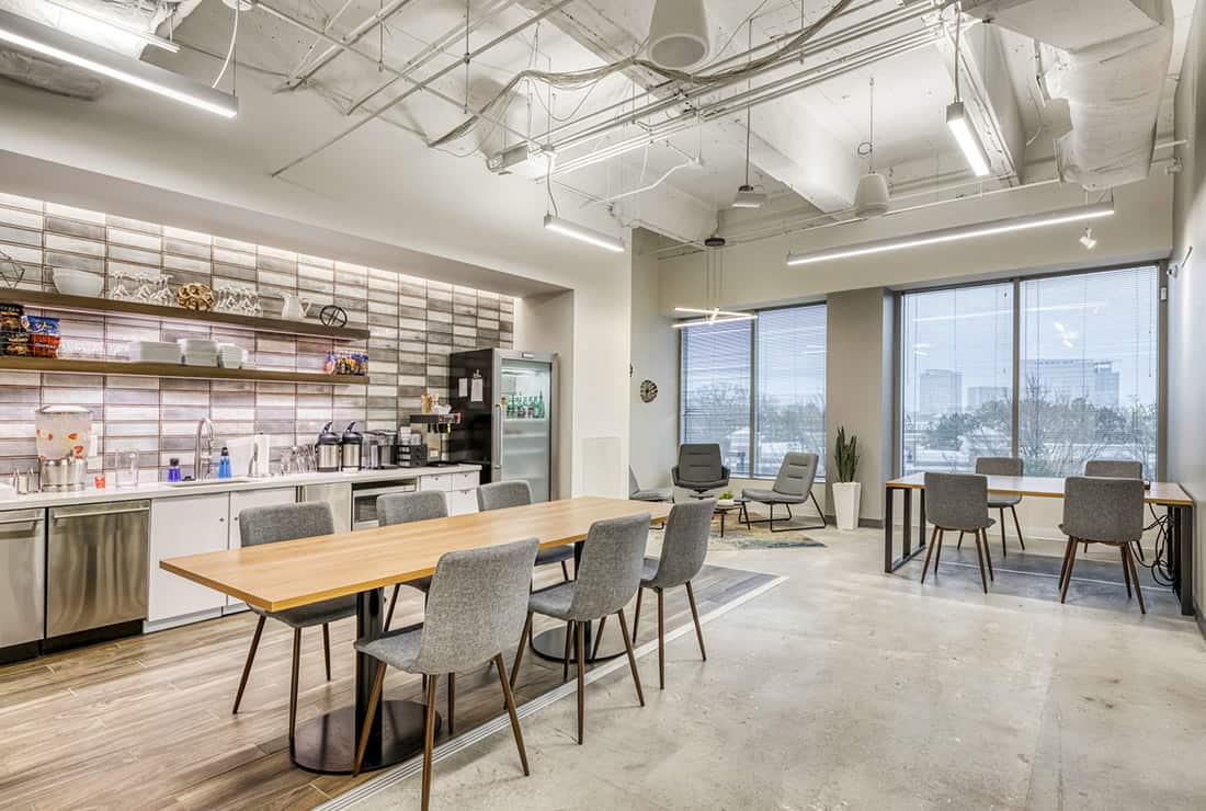 View of the open cafe area next to Coworking seating and outdoor views of the city.