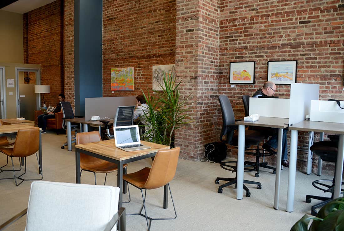 Members working independently throughout the Coworking area.