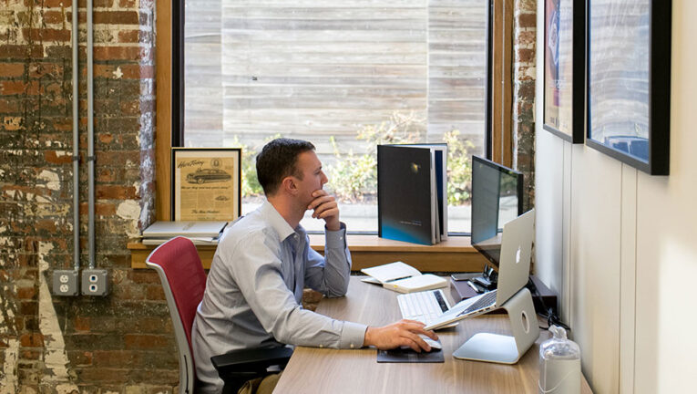 Man working at a Dedicated Desk in Coworking area by the window.